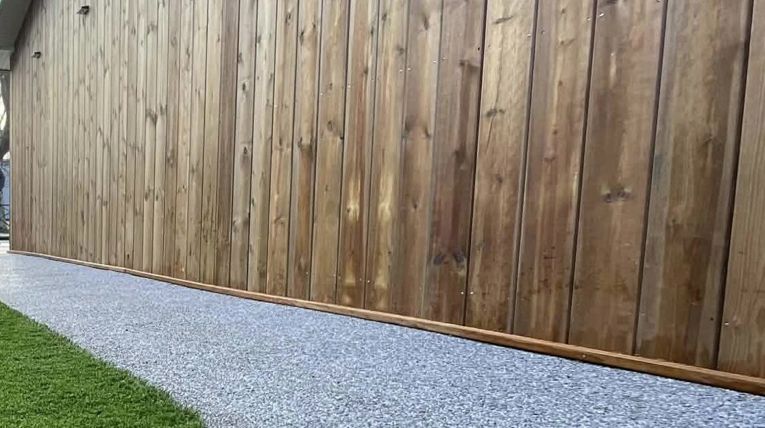 Aménagement de carport en bois intégré dans un jardin paysager