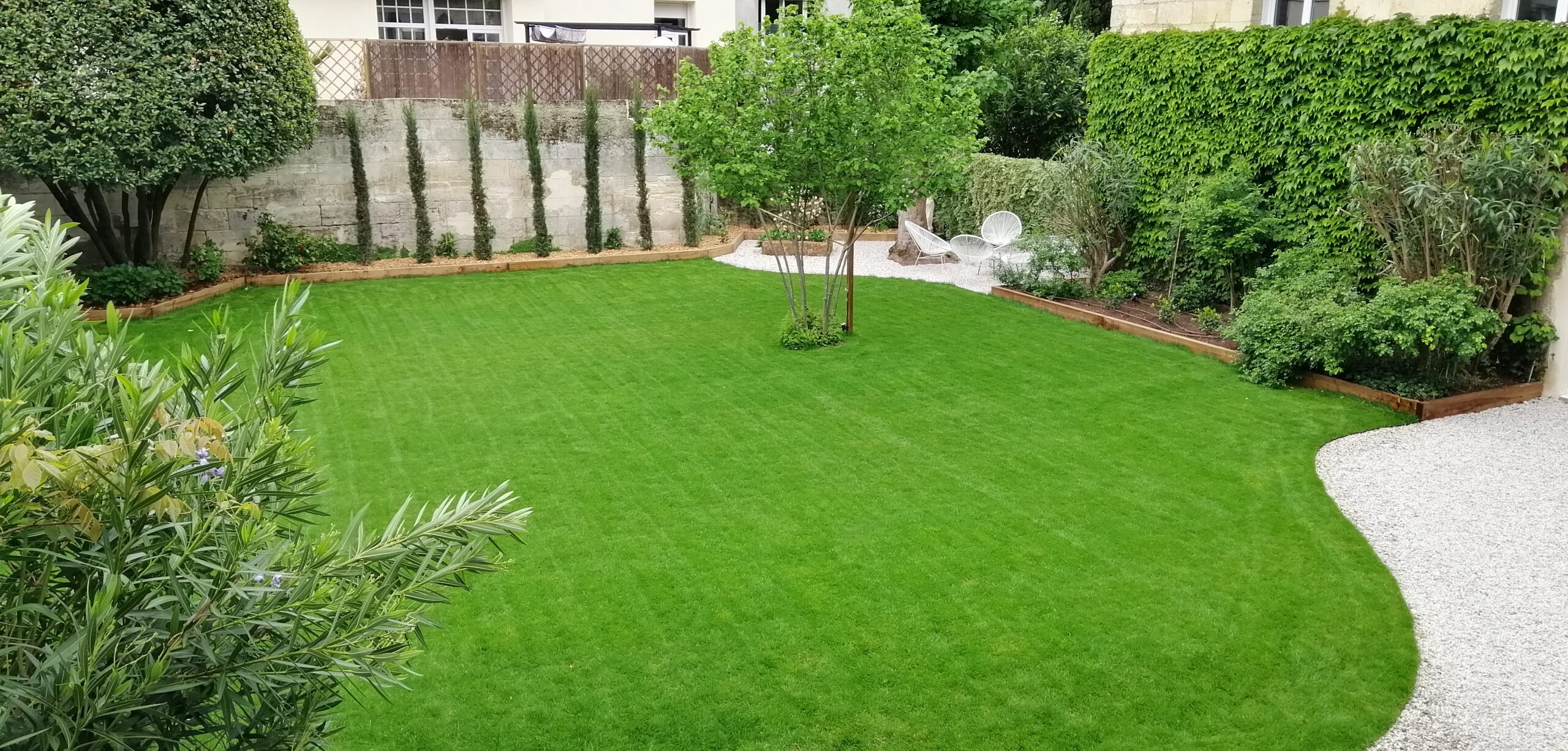 Aménagement extérieur complet avec cheminement minéral et massifs fleuris en Gironde